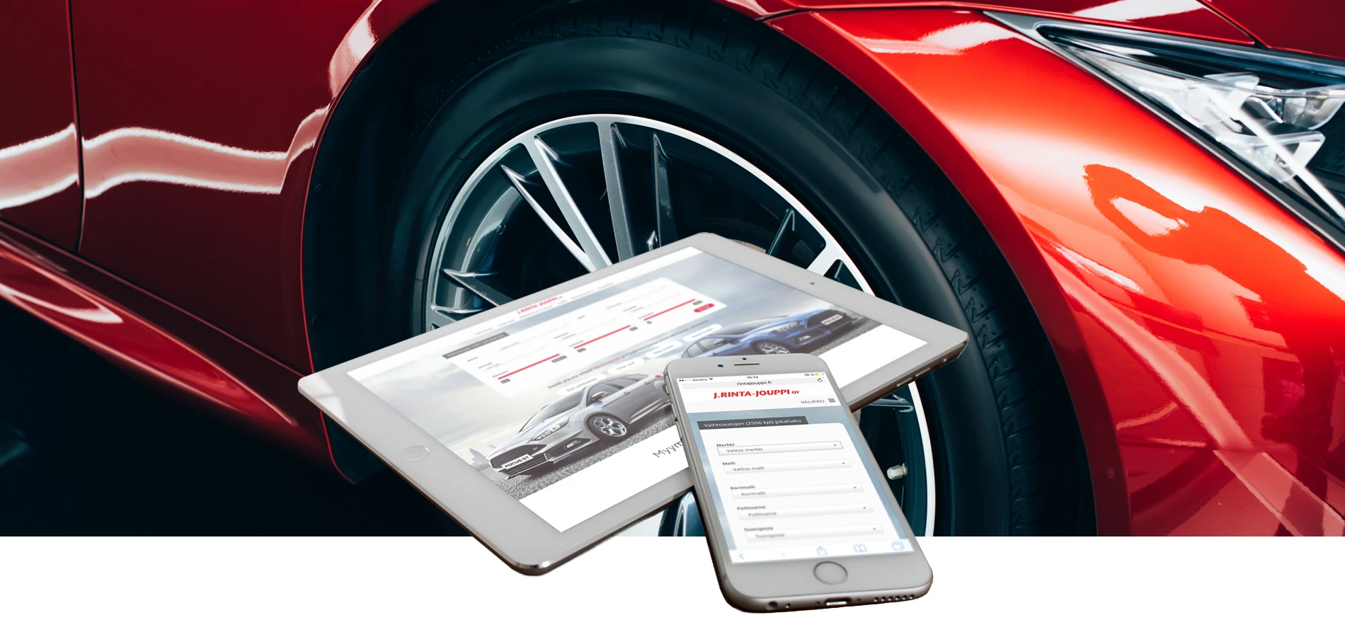 Tablet and smartphone resting on a red car's wheel, displaying a car listing web page and form on the screens, symbolizing online car shopping.
