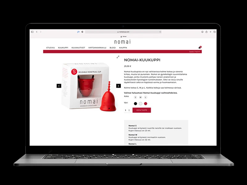 Laptop screen showing Nomai reusable menstrual cup product page with a red cup and packaging on the left and purchase options on the right, on a white background site layout.